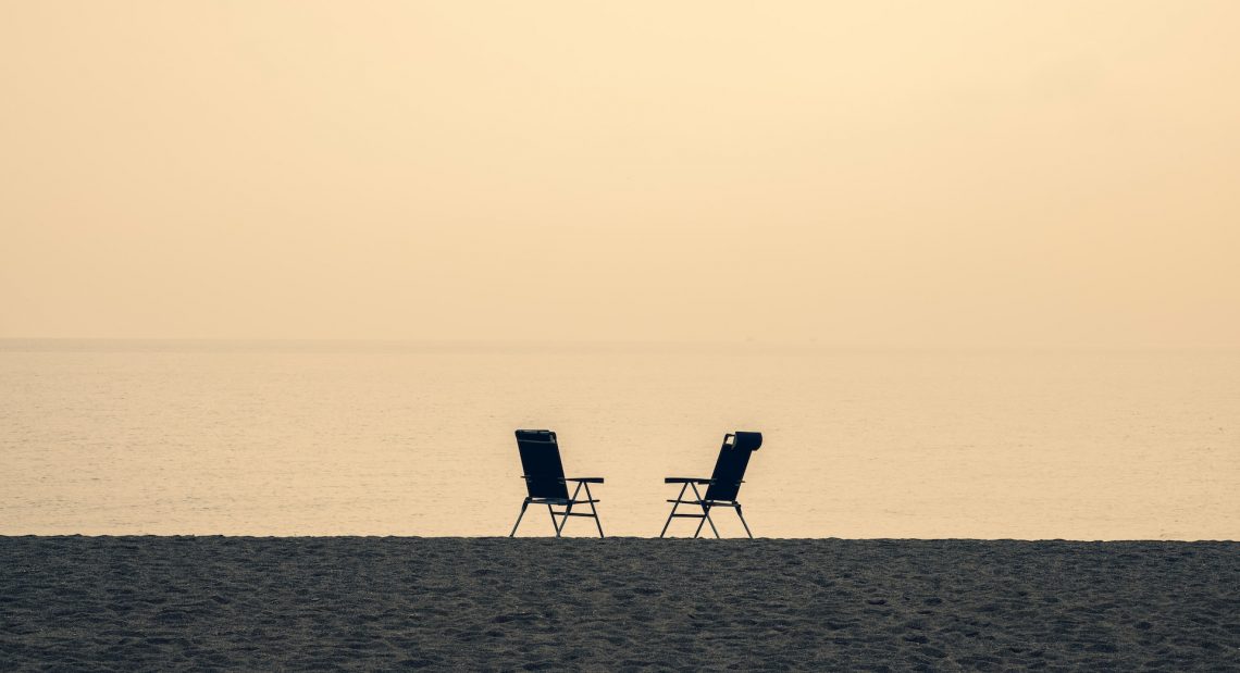 Two empty chairs at ocean coast