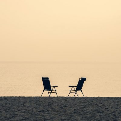 Two empty chairs at ocean coast